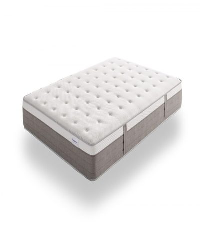 Vista elegante de un colchón premium sobre una base tapizada en un dormitorio moderno. El colchón luce capas acolchadas y tejidos suaves, transmitiendo confort, lujo y calidad superior.