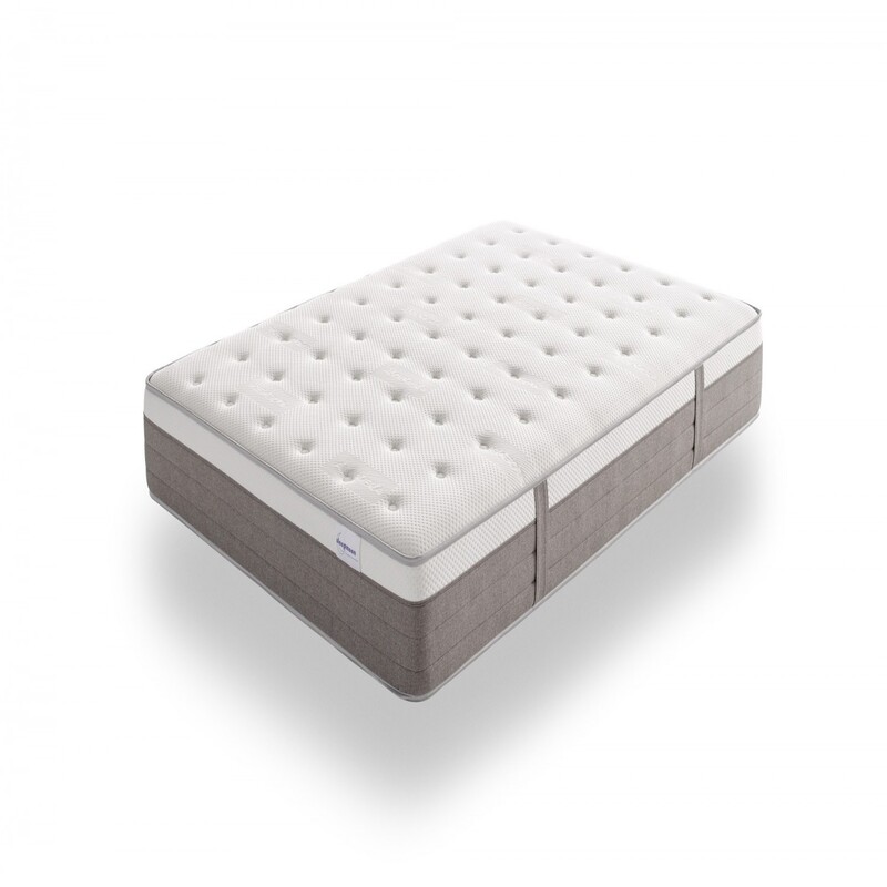 Vista elegante de un colchón premium sobre una base tapizada en un dormitorio moderno. El colchón luce capas acolchadas y tejidos suaves, transmitiendo confort, lujo y calidad superior.