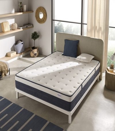 Colchón Prisma de diseño elegante sobre base de cama en dormitorio moderno, destacando sus capas y tejido premium para un descanso óptimo.