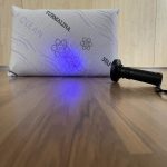Almohada viscoelástica autolimpiable sobre cama blanca, con funda de tejido técnico que resalta su diseño moderno y funcionalidad higiénica.