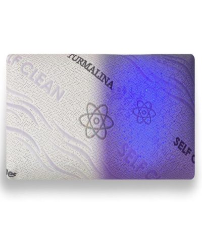 Almohada viscoelástica autolimpiable sobre cama blanca, con funda de tejido técnico que resalta su diseño moderno y funcionalidad higiénica.