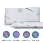 Almohada viscoelástica autolimpiable sobre cama blanca, con funda de tejido técnico que resalta su diseño moderno y funcionalidad higiénica.